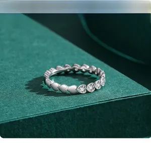 Close-up of S925 sterling silver heart-shaped ring with pavé zircons on green box