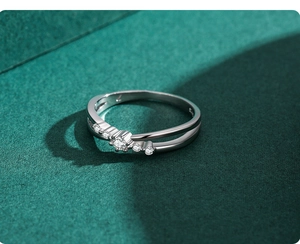 Détail macro de bague en argent s925 au design croisé sertie de cinq diamants brillants
