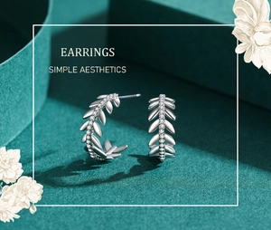 Detailed view of S925 silver leaf earrings with shimmering pavé set zirconia stones