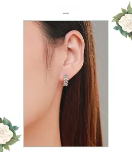Close-up of S925 sterling silver leaf stud earrings with pavé crystals on the ear lobe