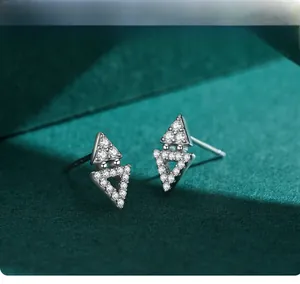 Macro shot of silver geometric triangle stud earrings with shiny cubic zirconia