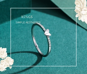 Close-up of S925 silver heart ring with sparkling zircons on a dark green background