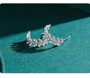Macro view of S925 sterling silver leaf stud earrings with pavé set zircon crystals