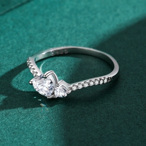 S925 sterling silver heart-shaped ring with pavé diamonds on a green textured surface