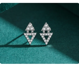 Macro shot of geometric S925 silver triangle stud earrings with shimmering pave zircons