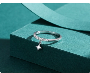 Macro d'une bague étoile en argent s925 avec zircons sur un support vert texturé