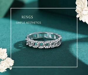Macro detail of silver Cuban chain ring with sparkling pave diamonds on green velvet