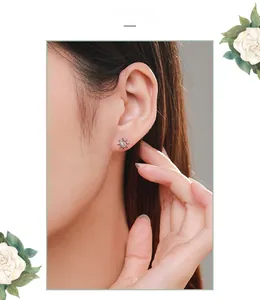 Close-up of S925 sterling silver sunburst stud earrings with zircon on woman's ear