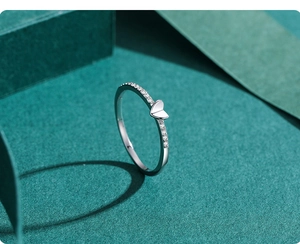 Close-up of heart-shaped s925 silver ring with zircon inlay on dark green background