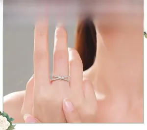Macro shot of S925 silver criss-cross ring featuring sparkling pavé diamonds on finger