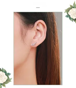 Close-up of elegant s925 silver curved ear studs with shimmering white cubic zirconia
