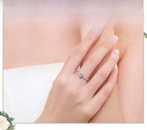Detailed view of pear shaped cubic zirconia ring on finger with micro paved silver band