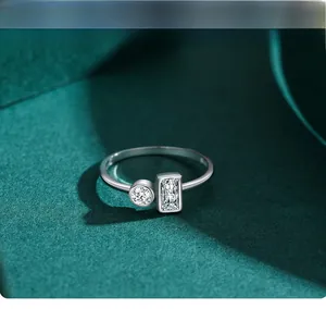 Macro shot of S925 silver ring featuring round and rectangular zircon stones on dark green paper