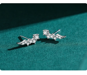 Macro detail of silver wing-shaped stud earrings with sparkling round cubic zirconia