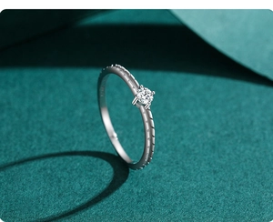 Macro detail of S925 silver ring featuring four-prong solitaire setting and textured band