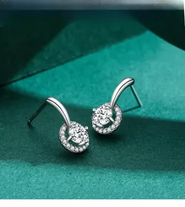 Vue macro des boucles d'oreilles halo en argent S925 avec zircons sur velours vert