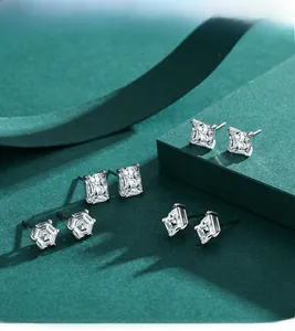Detailed close-up of S925 silver stud earrings with geometric cubic zirconia on dark green stands