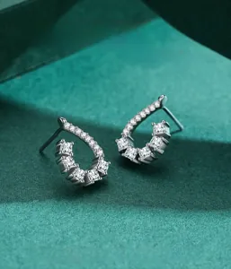 Macro view of teardrop silver stud earrings with glittering zircon stone pavé setting