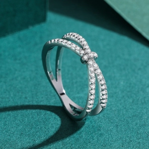 Luxurious S925 silver criss-cross ring with pavé-set zircons on dark green background