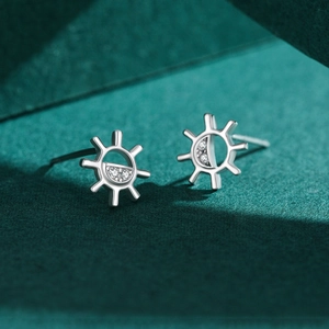 S925 silver sun and moon stud earrings with zircon inlay on a dark green background