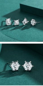 Macro shot of silver hexagon and rectangular cut stud earrings on green cubes