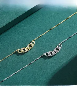 Detailed view of silver and gold geometric interlocking pendant necklaces with tiny zircons