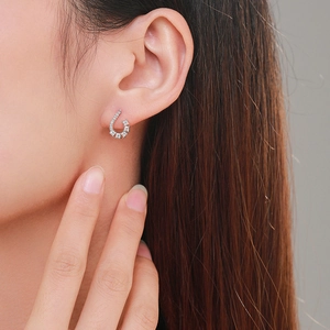 Elegant S925 silver C-shaped stud earrings with pavé zircons worn by a model