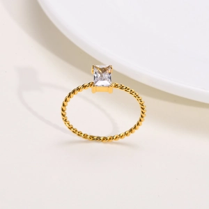 Detailed shot of a gold twist band ring featuring a large rectangular white zircon stone