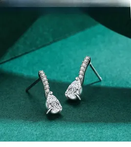 Macro shot of silver earrings with pear-cut drop and micro-paved cubic zirconia stones