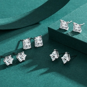 Set of four geometric S925 silver stud earrings with clear square zircons on green background