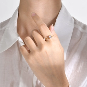 Detail of gold twisted band ring featuring a rectangle clear zircon on a model's hand