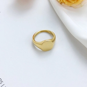 Macro detail of high-polish 18K gold plated stainless steel oval signet ring surface