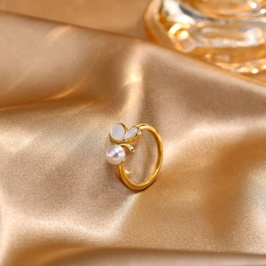 Adjustable golden shell leaf ring with white pearl on premium satin background