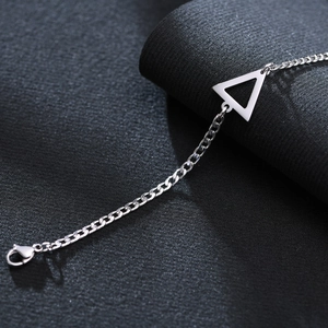 Macro shot of silver stainless steel triangle pendant on a minimalist chain with clasp