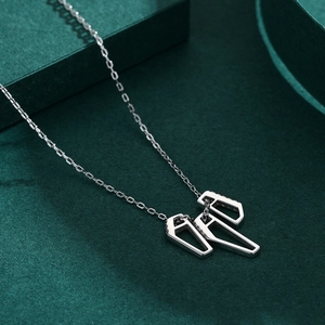 Collier moderne en argent s925 avec triple pendentif géométrique sur présentoir vert