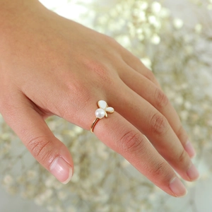 Detail of adjustable gold ring with white butterfly shell motif and central pearl accent
