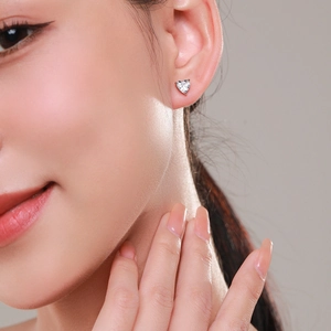 Classic S925 silver heart-cut cubic zirconia stud earrings worn on a model's ear
