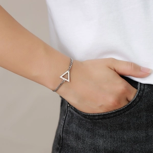 Close-up of geometric stainless steel triangle pendant on a curb chain bracelet