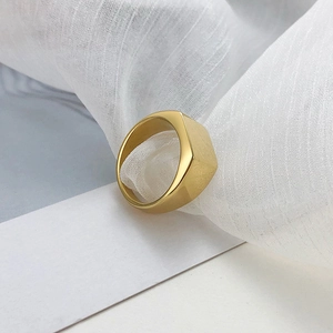 Vue macro d'une bague géométrique dorée avec finition en métal brossé et mat