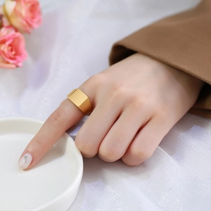 Gros plan détaillé d'une bague chevalière dorée minimaliste portée au doigt