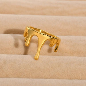 Macro shot of molten gold-plated ring with liquid-like texture in a beige jewelry box