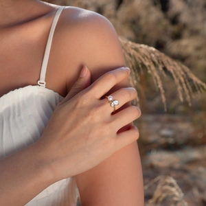 Detail of adjustable gold shell ring with butterfly design worn in natural light