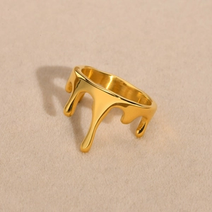 Macro detail of gold lava ring with mirror-polished finish and fluid drop design