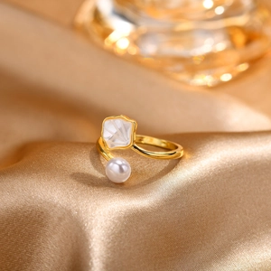 Detailed close-up of adjustable gold ring featuring white pearl and shell flower accents