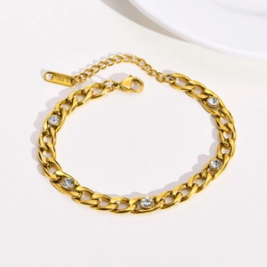 Detailed view of gold stainless steel link bracelet with five white cubic zirconia stones