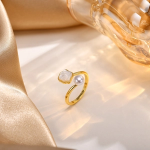 Close-up of golden adjustable ring with a white pearl and shell-textured mother of pearl