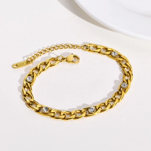 Detailed macro view of gold stainless steel link bracelet with five clear zircon stones