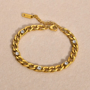 Gold stainless steel NK link bracelet with five clear cubic zirconia stones on beige velvet