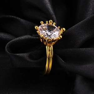 Luxurious gold copper ring with large oval zircon in a royal crown setting on black silk