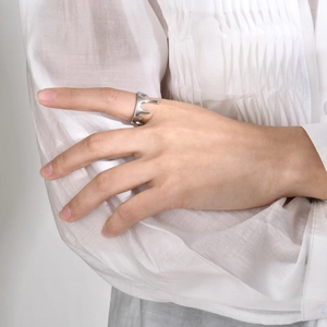 Close-up of silver irregular lava fluid ring worn by model with modern style